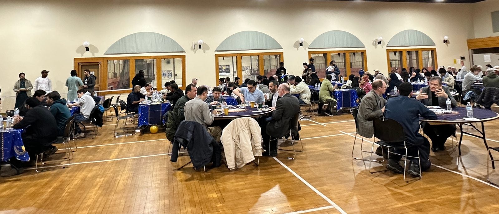Guests sharing dinner at round tables during MSA’s Grand Iftar at the Dee Stadium Ballroom, March 2026